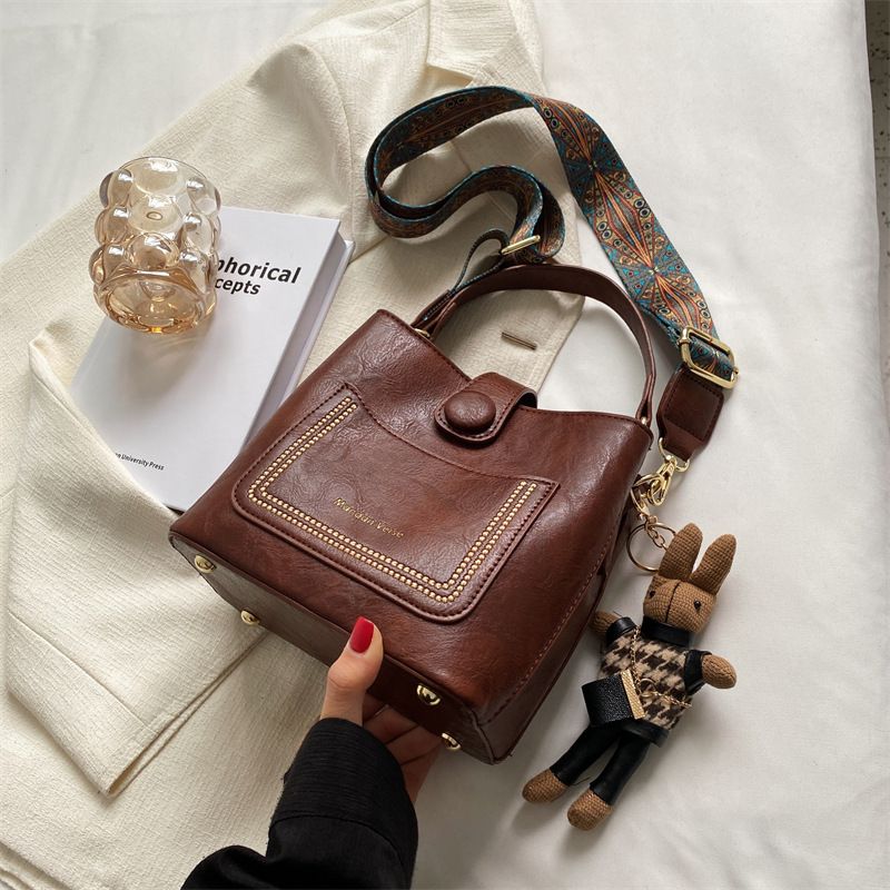 Design Kvinder 2023 Efterår Og Vinter Ny Populær Messenger Bag Med Bred Skulderrem Retro Bærbar Bøttetaske